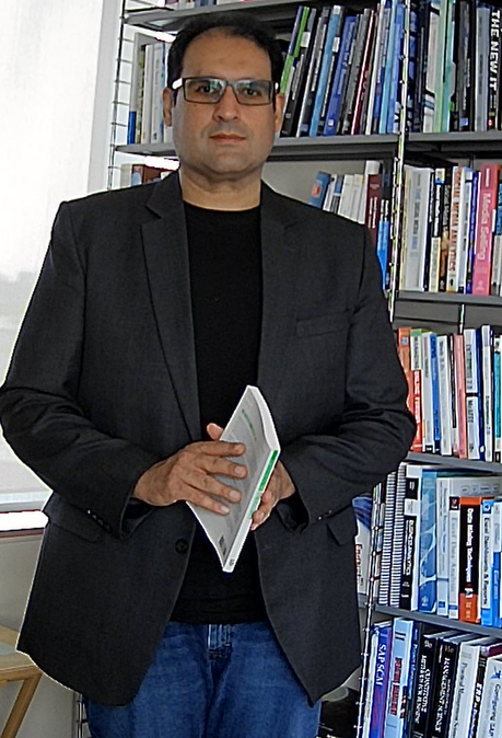 Umar standing with books in background